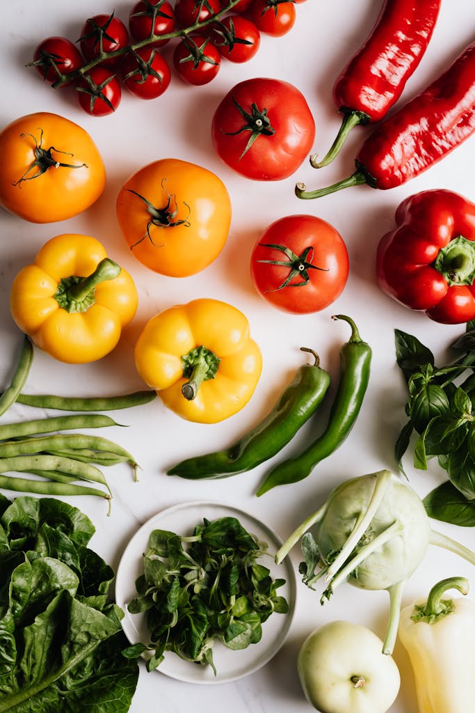 Vibrant top view arrangement of mixed fresh vegetables including peppers and tomatoes.